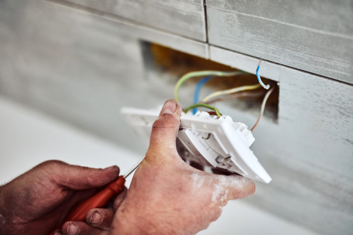 electricien fixant les fils dans une nouvelle prise