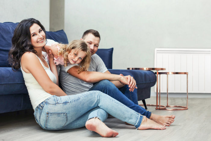Famille dans son salon avec un chauffage electrique Aterno. Une bonne alternative au remplacement de votre chaudiere au fioul.